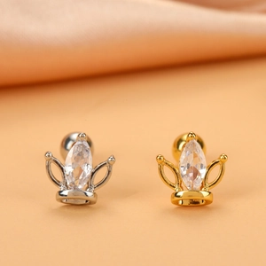 Detail of gold and silver crown stud earrings with marquise-cut zircon on satin background