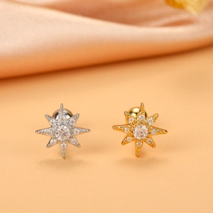 Detailed macro view of 16G gold and silver star earrings with brilliant zircon inlays