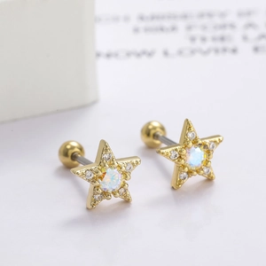 Macro detail of star-shaped gold ear studs with iridescent stone and zirconia inlay