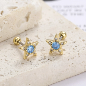 Detailed macro view of gold star-shaped helix studs with blue stone and screw-back ball