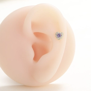 18k vergoldeter Herzstecker mit lila Zirkon und weißen Kristallen am Ohrläppchen