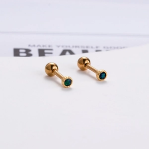 Dettaglio di orecchini 16G in acciaio dorato con pietre di opale verde brillante