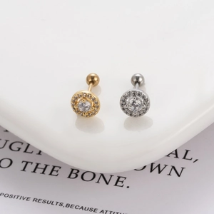 Detail of round zircon stud earrings in gold and silver with ball screw back closures
