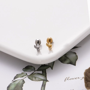 Dettaglio di orecchini a vite con ape e zirconi in finitura oro e argento