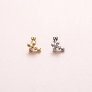 Close-up of cross stud earrings with tiny gems in gold and silver finishes on pink texture