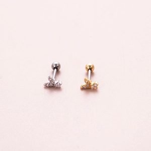 Close-up of butterfly stud earrings with sparkling cubic zirconia in gold and silver finish