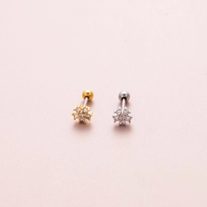 Close-up of gold and silver flower cartilage earrings with sparkling cubic zirconia