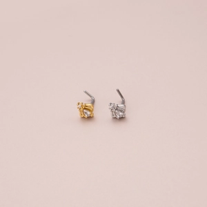 Detail of L-shaped nose studs with butterfly design and teardrop zircon in gold and silver