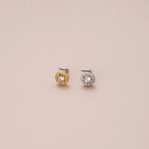 Macro view of L-shaped nose studs with round cubic zirconia halo in gold and silver