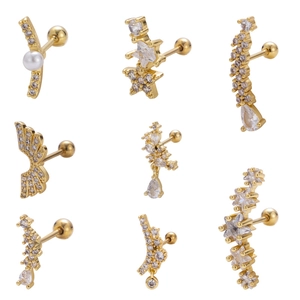 Détail des piercings d'oreille en plaqué or 18 carats avec ailes et étoiles en zircone