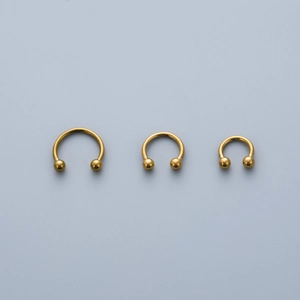 Three gold stainless steel horseshoe rings in varying sizes with polished finish