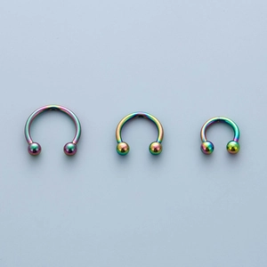 Three rainbow surgical steel horseshoe nose rings in various sizes with ball closures
