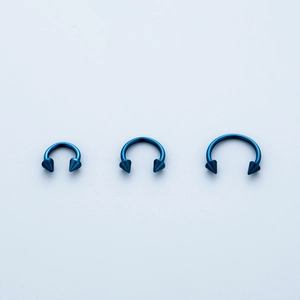 Three blue stainless steel circular barbells with spikes for nose and ear piercing