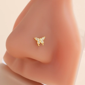 Detail shot of a butterfly nose stud with gold plating and micro-inlaid white zircons