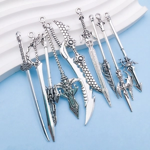 Macro view of vintage silver alloy sword charms with intricate antique carvings and detail