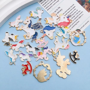 Detail of colorful enamel unicorn and rocking horse alloy charms with gold metal loops