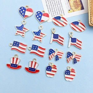 Close-up of assorted American flag themed enamel charms on a light blue fabric background