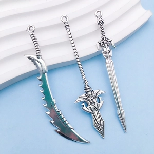 Macro shot of vintage silver alloy sword charms with detailed fantasy weapon engraving