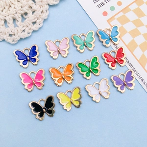 Flat lay macro of colorful enamel butterfly pendants for DIY jewelry making accessories