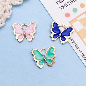 Detailed macro of colorful enamel butterfly pendants with golden alloy edges for DIY jewelry