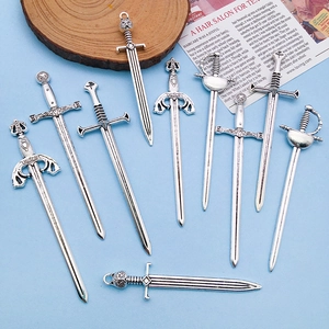 Set of 9 vintage silver alloy sword charms with intricate cross and lion head designs
