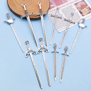 Detailed view of nine vintage tibetan silver sword pendants for jewelry DIY projects