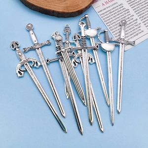 Macro view of vintage silver alloy sword charms with intricate gothic relief details
