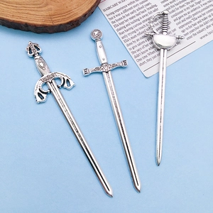 Detail showing three vintage silver gladiator sword charms with intricate metal carvings