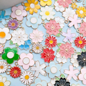 Makroansicht verschiedener Emaille-Blumenanhänger mit Goldrand für DIY-Schmuck