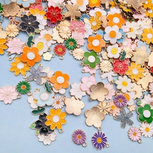 Makroaufnahme verschiedener bunter Emaille-Blumenanhänger für DIY-Schmuck und Bastelarbeiten