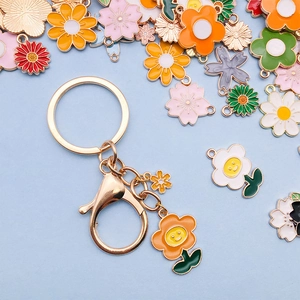 Goldener Blumen Schlüsselanhänger mit orangefarbenem Emaille-Anhänger und Smiley-Motiv