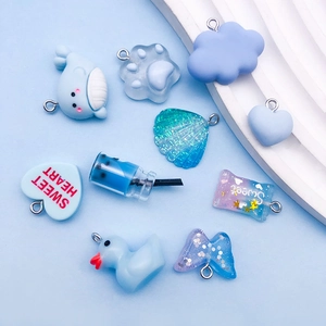 Macro shot of assorted blue resin charms with glitter details for DIY jewelry making
