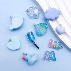Macro shot of cute blue resin charms including dolphin, duck and butterfly for DIY jewelry