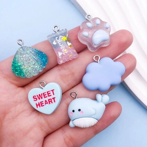 Detailed view of assorted resin DIY pendants featuring blue hearts and candy shapes