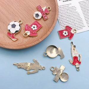 Detail of soccer themed alloy charms showing front and back with gold plating and enamel finish