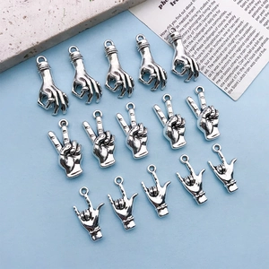 Macro view of antique silver hand gesture charms for DIY jewelry making and necklaces