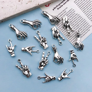Macro detail of antique silver alloy hand gesture charms for DIY jewelry making and crafts