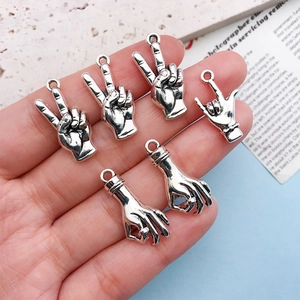 Macro view of silver alloy hand gesture charms for DIY jewelry making and bracelets