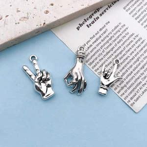 Macro detail of three silver gesture charms for DIY jewelry making with top ring loops