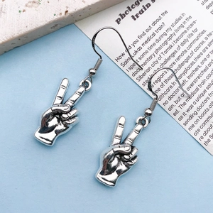 Detail showing S925 sterling silver stamp and peace sign gesture on retro silver earring