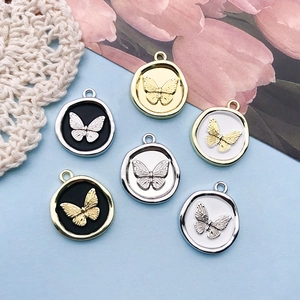 Detailed close-up of 18x21mm butterfly round charms with wax seal effect in alloy metal