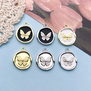 Detail of round butterfly alloy charms in gold and silver for DIY jewelry making
