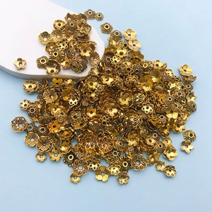 Vue macro détaillée de calottes de perles en fleurs dorées et d'entretoises pour bijoux DIY