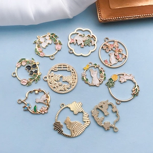 Detailansicht verschiedener Emaille-Anhänger mit Katzen und Blumen für DIY-Schmuck