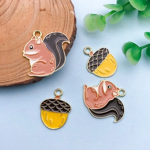 Macro view of colorful enamel squirrel and acorn charms for DIY jewelry making