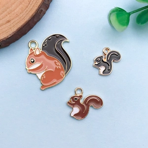 Detailed close-up of three enamel squirrel charms for DIY jewelry making and crafts