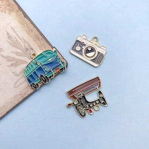 Detailed view of vintage enamel charms including a blue van camera and sewing machine