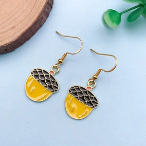 Detailed close-up of handmade yellow acorn alloy charms with enamel finish and gold hooks