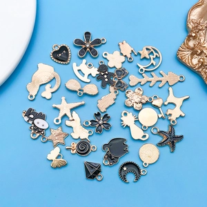 Primer plano de dijes de esmalte negro para creación de joyas DIY y pulseras artesanales