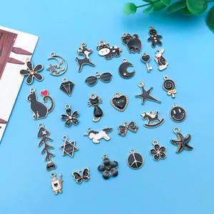 Detalle de dijes de esmalte blanco y negro con bordes dorados para crear joyas DIY